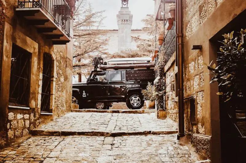 a black truck parked in an alley between buildings