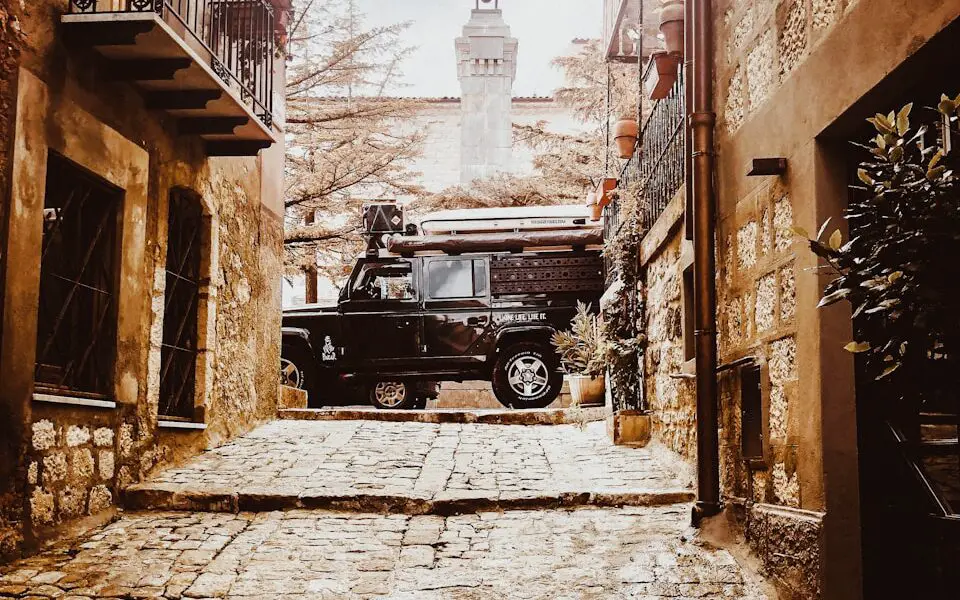 a black truck parked in an alley between buildings