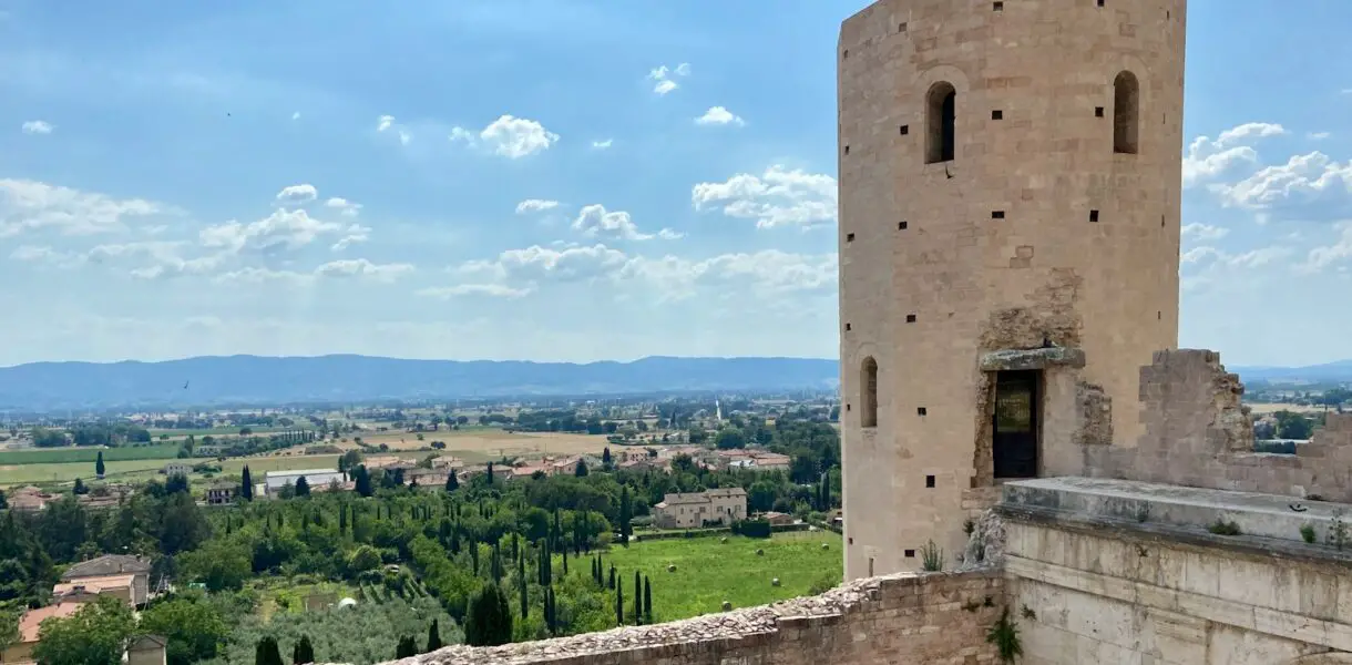 brown concrete building near green trees under blue sky during daytime