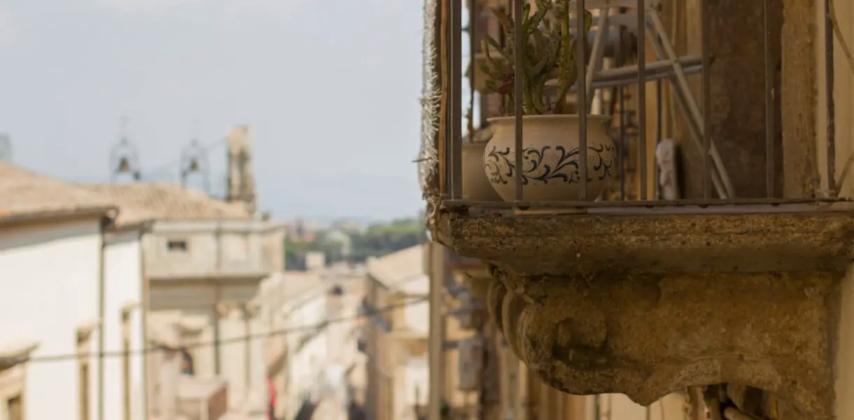 brown and black floral flower pot on balcony during daytime