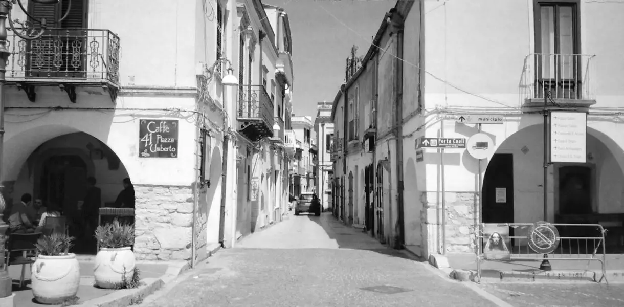 grayscale photo of empty street in between buildings