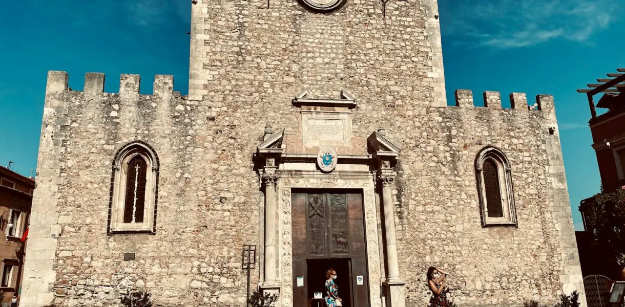 people walking near brown concrete building under blue sky during daytime