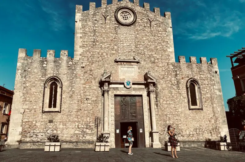 people walking near brown concrete building under blue sky during daytime