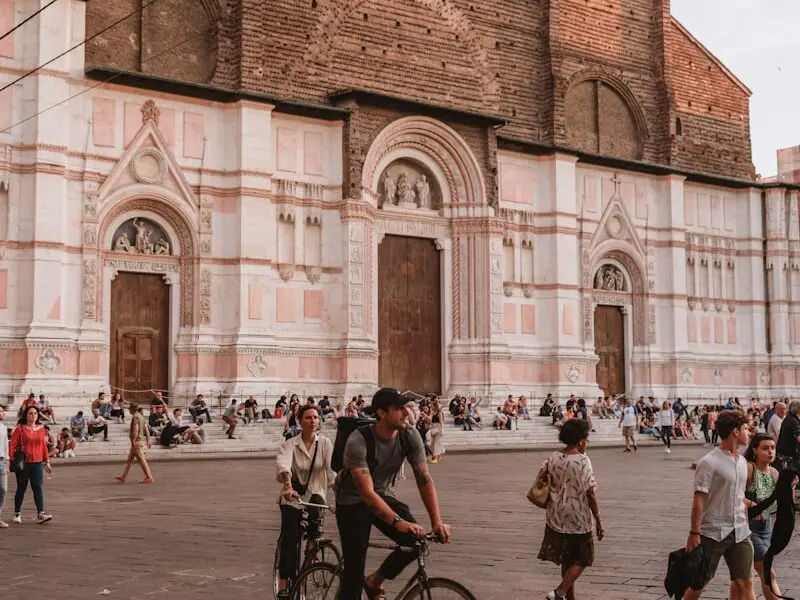 a man riding a bike down a street next to a tall building