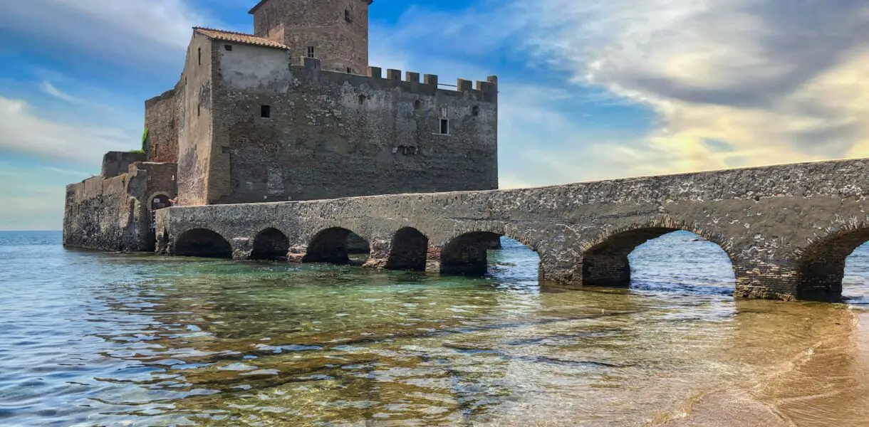 brown concrete building on water under blue sky during daytime