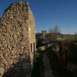 an old stone building with a path between it