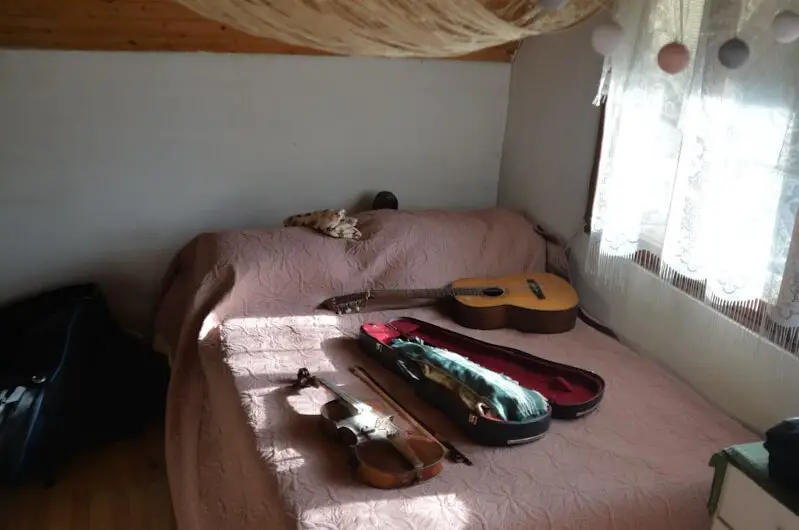 a bedroom with a bed, dresser and a window